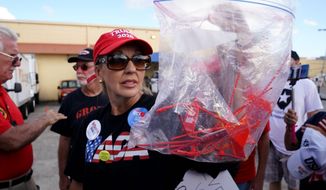A woman holds a bag of plastic seals as she says were found outside Broward County election offices during a ballot recount in Lauderhill, Florida, U.S., November 12, 2018.  REUTERS/Carlo Allegri - RC1B0C2FD760