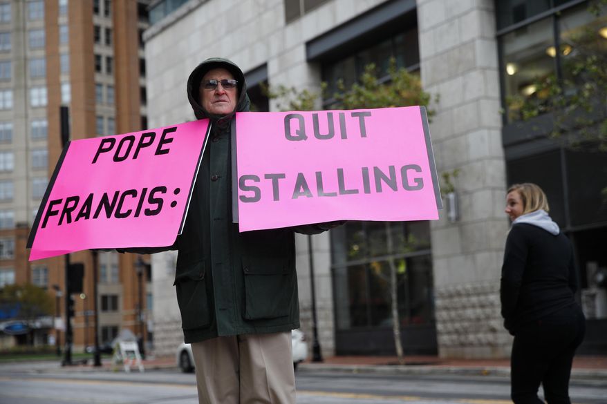 Robert Hoatson, of West Orange, N.J., holds protest signs outside of a hotel hosting the United States Conference of Catholic Bishops&#39; annual fall meeting, Tuesday, Nov. 13, 2018, in Baltimore. (AP Photo/Patrick Semansky)