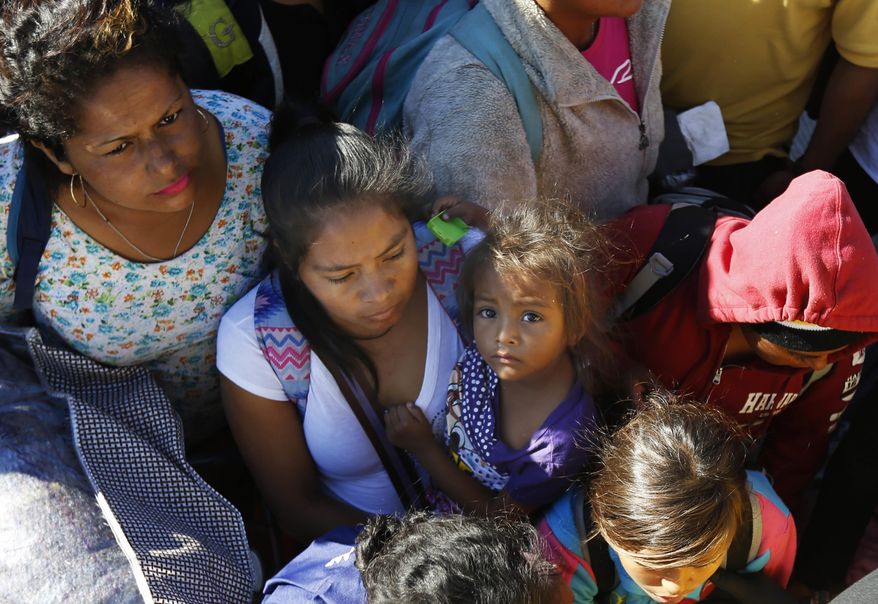 Migrants traveling with a caravan hoping to reach the U.S. border, wait to board a bus in La Concha, Mexico, Wednesday, Nov. 14, 2018. Buses and trucks are carrying some migrants into the state of Sinaloa along the Gulf of California and further northward into the border state of Sonora. The bulk of the main caravan appeared to be about 1,100 miles from the border, but was moving hundreds of miles per day. (AP Photo/Marco Ugarte)