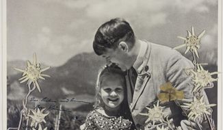In this 1933 photo released by Alexander Historical Auctions, Adolf Hitler embraces Rosa Bernile Nineau, who was nearly 6,, at his mountainside Bavarian retreat in Germany. The black-and-white image taken by Heinrich Hoffmann shows Hitler embracing Nineau who had a Jewish grandmother,  has sold at auction for more than $11,000. The photograph is inscribed by Hitler himself in dark blue ink. (Heinrich Hoffmann/Alexander Historical Auctions via AP)