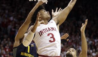 Indiana&#39;s Justin Smith (3) grabs a rebound next to Marquette&#39;s Brendan Bailey (1) and Theo John (4) during the first half of an NCAA college basketball game Wednesday, Nov. 14, 2018, in Bloomington, Ind. (AP Photo/Darron Cummings)