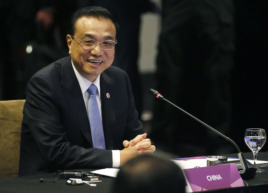 Chinese Premier Li Keqiang smiles as he glances at ASEAN leaders after delivering his statement at the ASEAN Plus China Summit in the ongoing 33rd ASEAN Summit and Related Summits Wednesday, Nov. 14, 2018 in Singapore. China&#39;s premier sought Tuesday to reassure its neighbors that Beijing will push ahead with reforms needed to support growth across the region and also keep the peace in contested waters in the South China Sea. (AP Photo/Bullit Marquez)