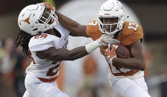 FILE - In this Saturday, April 21, 2018 file photo, Texas wide receiver Jerrod Heard (13) is hit by defensive back Jarmarquis Durst (28) after making a catch during the NCAA college football team&#39;s Orange-White spring game in Austin, Texas. Once upon a time, Jerrod Heard had “the juice.” He was the quarterback of the future for the Texas Longhorns and he’d just smashed Vince Young’s single-game school for total offense. He could throw. He could run. He could do just about everything. Then all that juice dried up with a whole lot of losing. A fifth-year senior, Heard heads into his final home game this week as a fifth-option wide receiver and special teams guy. (AP Photo/Eric Gay, File)