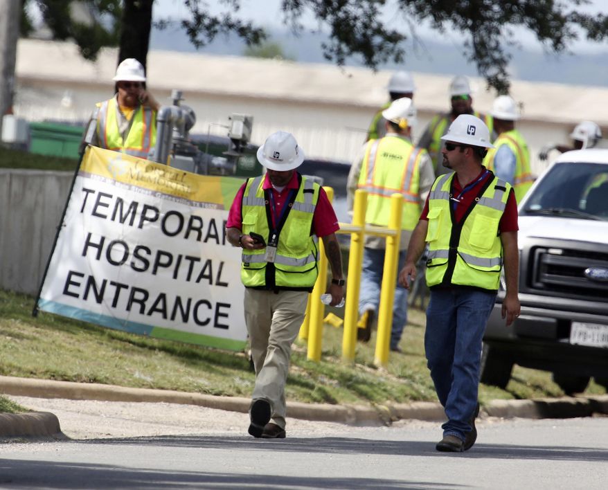 FILE - In this June 26, 2018, file photo, construction workers leave a temporary entrance to Coryell Memorial Healthcare System hospital where an explosion in a building under construction injured several people, and knocked power out for a large portion of the city in Gatesville, Texas. Investigators say an explosion that killed three people and injured 13 others at the Texas hospital earlier this year was caused by natural gas that leaked into a boiler room and an adjacent mechanical room. (Rod Aydelotte/Waco Tribune-Herald via AP, File)