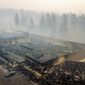 Smoke hangs over the scorched remains of Old Town Plaza following the wildfire in Paradise, Calif., on Thursday, Nov. 15, 2018. The shopping center housed a Safeway and other businesses. (AP Photo/Noah Berger)
