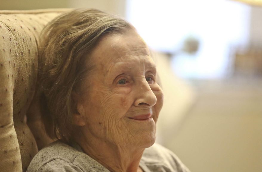 In this Nov. 1, 2018 photo, Lorriane Baer, 99, smiles as she holds a photo of herself and talks about her time as a Army nurse at her home in WWII at in Decatur, Ill. During World War II, it was every American's patriotic duty to serve the war effort in some way.For many of the men, that was putting on a uniform and going to fight. For a lot of women, it meant joining the women's branches of each armed service, which were separate then. H. Lorraine Eades, as she was known then, was finishing up nursing school at John C. Proctor Hospital in Peoria when an Army recruiter came to visit and asked the students if they would serve. On Veterans Day 2018, she and the women in that class represent a critical component of the war effort. (Clay Jackson/Herald & Review via AP)