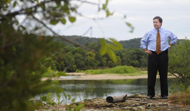 FILE - In this July 16, 2009, file photo, Oklahoma Attorney General Drew Edmondson stands by the Illinois river in Tahlequah, Okla., when he sued 12 Arkansas poultry companies for polluting the Illinois River watershed. Conservation groups are expressing disappointment with an agreement between Oklahoma and Arkansas officials to study ways to improve water quality in the Illinois River watershed. The groups say the agreement fails to control pollution of the river in Oklahoma and merely calls for another study of the river&#x27;s basin. (AP Photo/Brandi Simons, File)