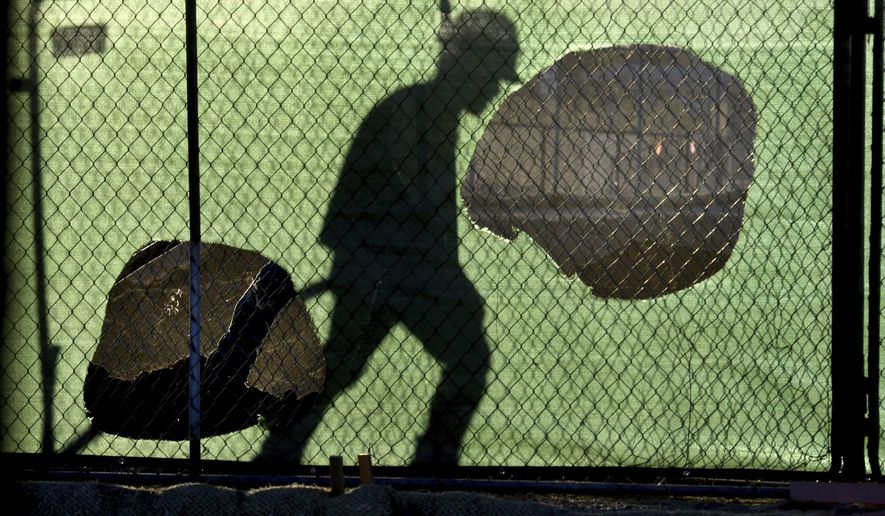 FILE - In this Wednesday, Nov. 14, 2018 file photo, the shadow of a worker falls on a fence at the construction site of a convenience store in Victorville, Calif. On Thursday, Nov. 15, 2018, the Centers for Disease Control and Prevention said the workers with the highest suicide rates have construction, mining and drilling jobs. That was the finding of a report correcting an earlier study that mistakenly said farmers, lumberjacks and fishermen killed themselves most often. (James Quigg/The Daily Press via AP)