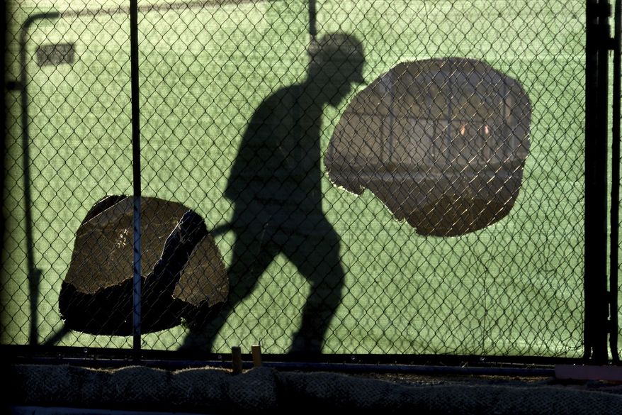 FILE - In this Wednesday, Nov. 14, 2018 file photo, the shadow of a worker falls on a fence at the construction site of a convenience store in Victorville, Calif. On Thursday, Nov. 15, 2018, the Centers for Disease Control and Prevention said the workers with the highest suicide rates have construction, mining and drilling jobs. That was the finding of a report correcting an earlier study that mistakenly said farmers, lumberjacks and fishermen killed themselves most often. (James Quigg/The Daily Press via AP)