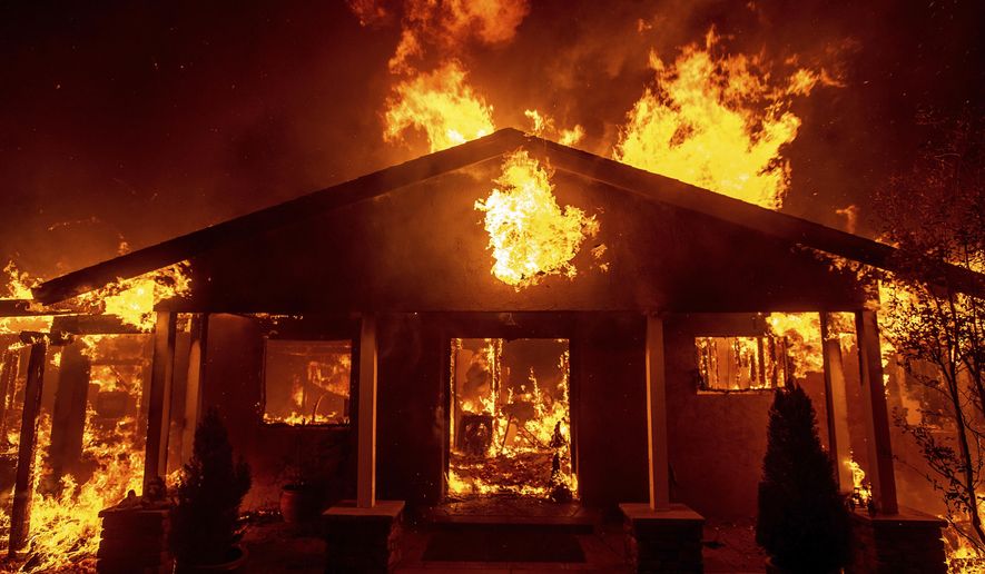 FILE - In this Thursday, Nov. 8, 2018 file photo, a home burns as the Camp Fire rages through Paradise, Calif. This town of 27,000 was destroyed in the deadliest, most destructive wildfire in California history. And memories are all that’s left for many of the survivors. They recall a friendly place where the pace was relaxed, where families put down roots and visitors opted to stay. (AP Photo/Noah Berger)