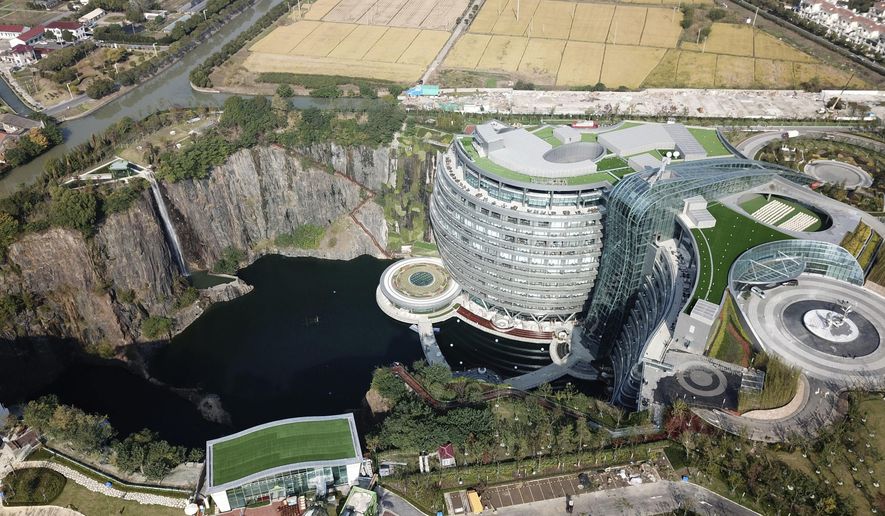 This Nov. 13, 2018, aerial photo and released on Thursday, Nov. 16, 2018 by Xinhua News Agency, shows the Intercontinental Shanghai Wonderland Hotel in Songjiang district of Shanghai, east China. The 18-story hotel has been built into the side of a huge hole in the ground left by a former put mine with sixteen of its floors below ground level. (Fang Zhe/Xinhua via AP)