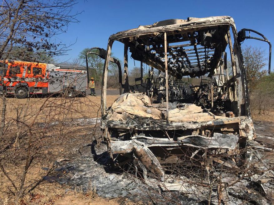 A fire engine is parked near to a burnt out bus after a bus accident in Gwanda about 550 kilometres south of the capital Harare, Friday, Nov. 16, 2018. Police in Zimbabwe say more than 40 people have been killed in a bus accident on Thursday night. (AP Photo)