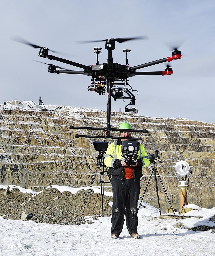 In this Nov. 9, 2018, photo, Ian Fairweather, of Montana Resources, operates a drone that is specially designed to haze waterfowl that land on the Berkeley Pit, a former open pit copper mine in Butte, Mont. Montana Resources uses boats, drones, rifles and sometimes fireworks to keep birds off of water in the pit, filled with water that is heavily acidic. (Meagan Thompson/Montana Standard via AP)