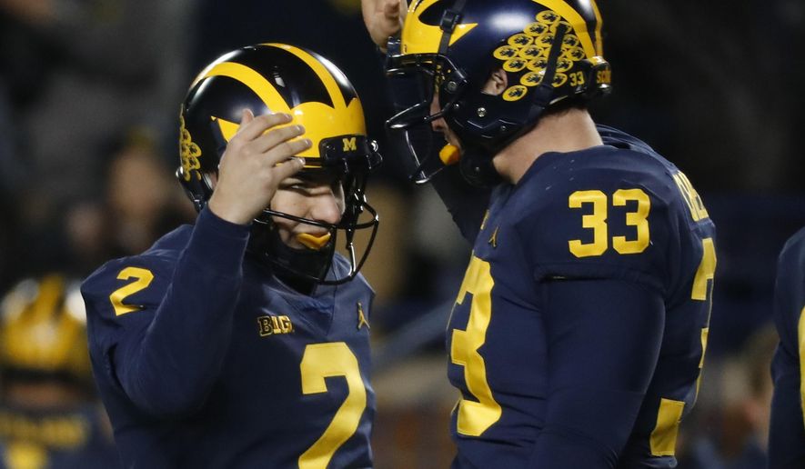 Michigan place kicker Jake Moody (2) celebrates kicking a 29-yard field goal with long snapper Camaron Cheeseman (33) in the second half of an NCAA college football game against Indiana in Ann Arbor, Mich., Saturday, Nov. 17, 2018. Michigan won 31-20. (AP Photo/Paul Sancya) ** FILE **