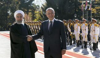 In this photo released by official website of the Office of the Iranian Presidency, Iraqi President Barham Salih, right, and his Iranian counterpart Hassan Rouhani shake hands during an official welcome ceremony for Salih at the Saadabad Palace in Tehran, Iran, Saturday, Nov. 17, 2018. Salih is visiting Iran less than two weeks after the United States restored oil sanctions that had been lifted under the 2015 nuclear deal. (Iranian Presidency Office via AP)