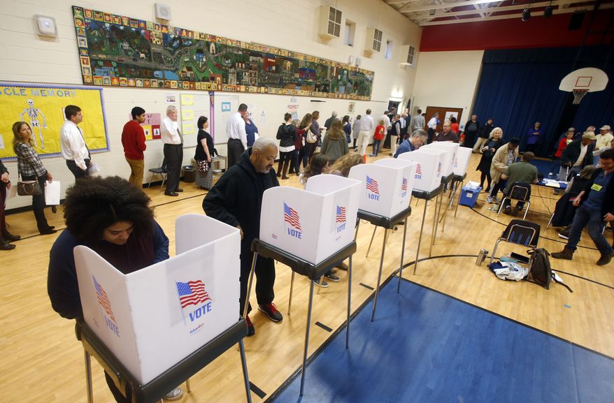 Voters fill out their ballots and wait in long lines to vote in Short Pump, Va., Tuesday, Nov. 6, 2018. (AP Photo/Steve Helber)