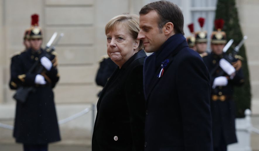 French President Emmanuel Macron and German Chancellor Angela Merkel arrive for a lunch the Elysee Palace after ceremonies Sunday, Nov. 11, 2018 in Paris. International leaders attended a ceremony in Paris on Sunday at mark the 100th anniversary of the end of World War I. (AP Photo/Thibault Camus)