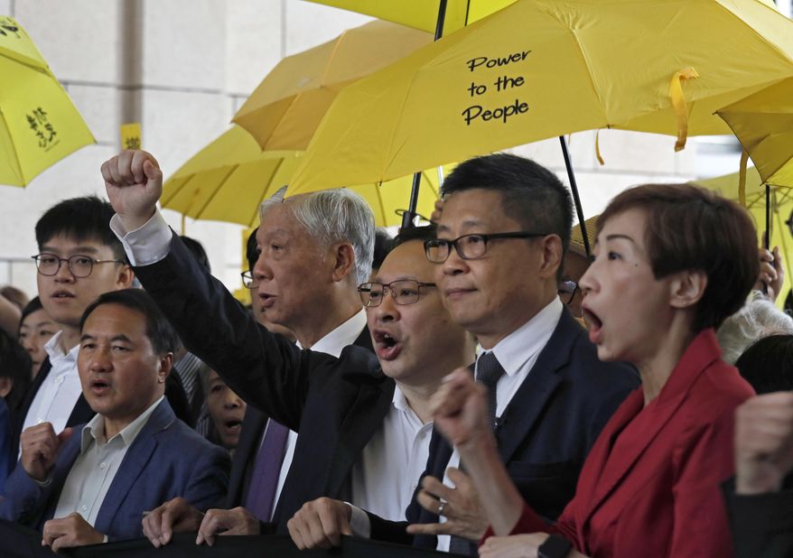 Occupy Central leaders, from right, Tanya Chan, Chan Kin Man, Benny Tai, Chu Yiu Ming and Lee Wing Tat shout slogans before entering a court in Hong Kong, Monday, Nov. 19, 2018. Nine leaders of the 2014 Hong Kong pro-democracy movement stand trial. The co-founders of the "Occupy Central" campaign - legal Prof. Benny Tai Yiu-Ting, sociology professor Chan Kin-man and retired pastor Chu Yiu-ming - are facing charges related to the planning and implementation of the campaign which became part of the large-scale pro-democracy Umbrella Movement protests which were carried out 79 days between September and December 2014. (AP Photo/Vincent Yu)