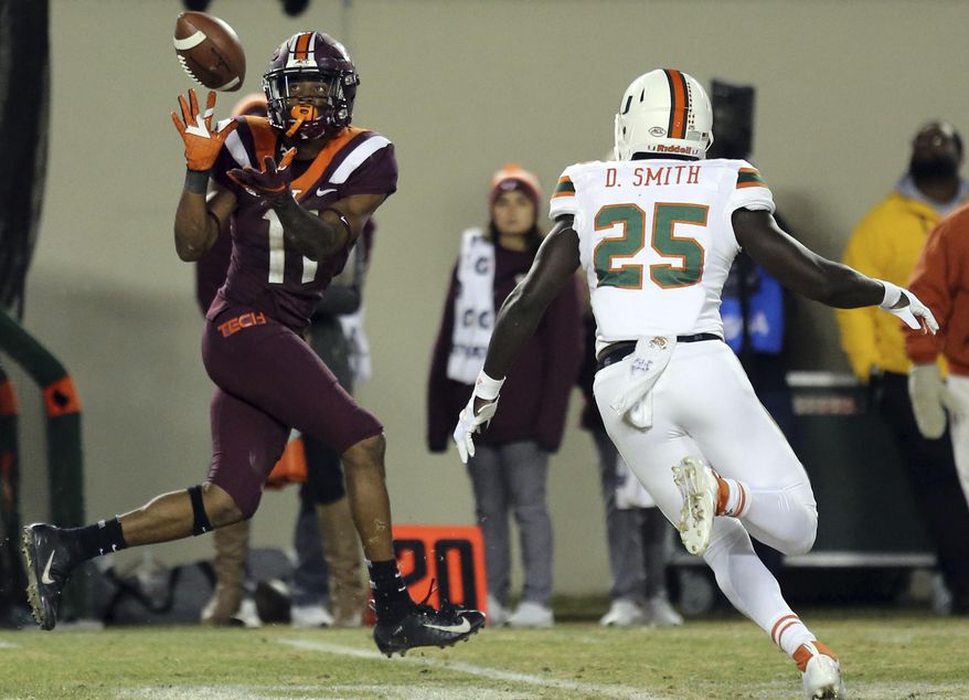 Virginia Tech receiver Tre Turner (11) catches a pass from quarterback Ryan Willis while evading Miami defender Derrick Smith (25) in the second half of an NCAA college football game in Blacksburg, Va., Saturday, Nov. 17 2018. (Matt Gentry/The Roanoke Times via AP)