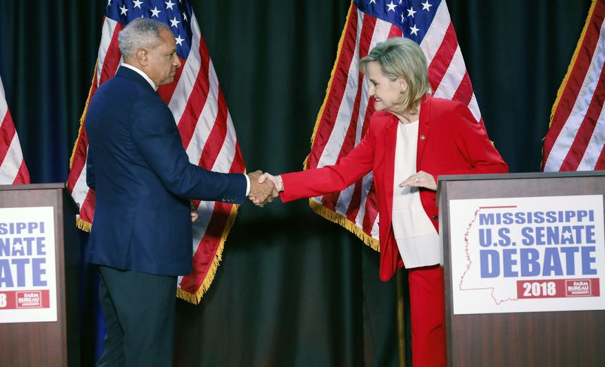 Appointed U.S. Sen. Cindy Hyde-Smith, R-Miss., and Democrat Mike Espy greet each other before their televised Mississippi U.S. Senate debate in Jackson, Miss., Tuesday, Nov. 20, 2018. (AP Photo/Rogelio V. Solis, Pool)