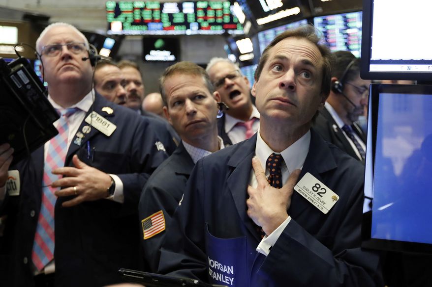 In this Wednesday, Nov. 14, 2018, file photo Dudley Devine, right, works with fellow traders on the floor of the New York Stock Exchange. On Tuesday, Nov. 20, stocks are opening sharply lower on Wall Street as a rout in major technology companies continued. (AP Photo/Richard Drew, File)