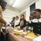 Second-grader KaMari Washington, right, enjoys a Thanksgiving meal with his classmates in Mitzi Collins classroom at Clark Elementary in Paducah, Ky. on Tuesday, Nov. 20, 2018. Parents provided traditional Thanksgiving dishes and the students were encouraged to dress as Native Americans or Pilgrims. (Ellen O&#39;Nan/The Paducah Sun via AP) ** FILE **