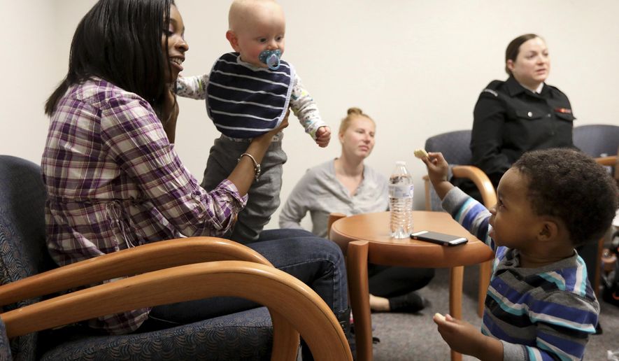 ADVANCE FOR USE SATURDAY, NOV. 24 - In this Nov. 8, 2018 photo, Shauna Hibbler-Cooley holds Travis Beer and talks to her own son Nathan, right, during a meeting of a postpartum support group at Naval Medical Center Portsmouth in Portsmouth, Va. In the background are Ashley Beer, Travis' mom, and Kayla Disbrow. (Steve Earley/The Virginian-Pilot via AP)