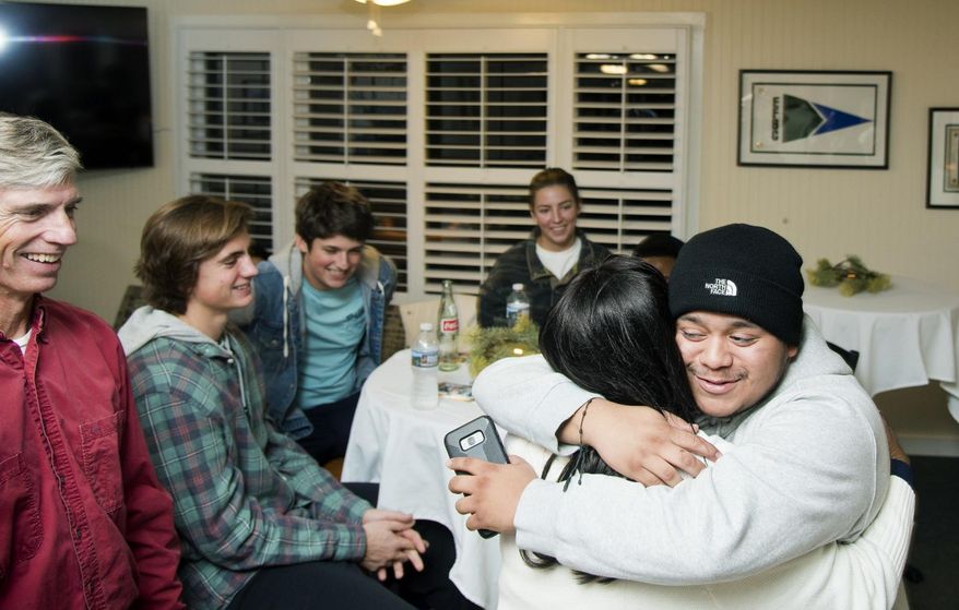 In this Nov. 18, 2018 photo, Jaime Artero, right, embraces Debbie Odum at the Friendsgiving meal in Epping Forest, Md., organized by the teen anti-gun violence group Hood2Good. (Joshua McKerrow/The Baltimore Sun via AP)