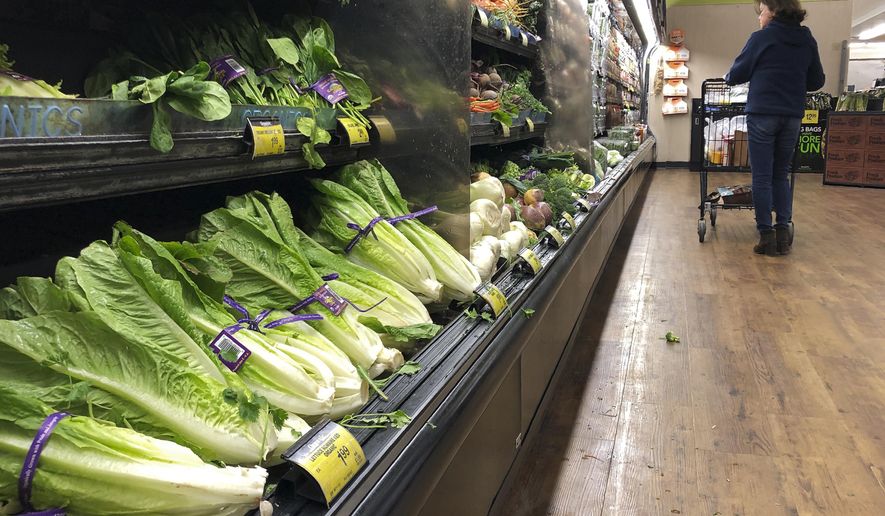 Romaine Lettuce still sits on the shelves as a shopper walks through the produce area of an Albertsons market Tuesday, Nov. 20, 2018, in Simi Valley, Calif. Health officials in the U.S. and Canada told people Tuesday to stop eating romaine lettuce because of a new E. coli outbreak. (AP Photo/Mark J. Terrill)