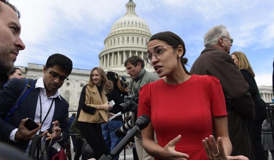 In this Nov. 14, 2018, file photo, Rep.-elect Alexandria Ocasio-Cortez, D-N.Y., talks with reporters following a photo opportunity on Capitol Hill in Washington, with the freshman class. (AP Photo/Susan Walsh, File)