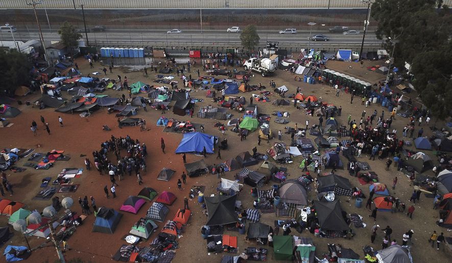 Central American migrants gather at a temporary shelter, near barriers that separate Mexico and the United States, in Tijuana, Mexico, Wednesday, Nov. 21, 2018. “I feel for the migrants who are arriving from other countries just like we did,” said Haitian immigrant Philocles Julda. “But you do adapt.” And work is plentiful in Tijuana, whose economy has been growing and whose factories have thousands of openings. (AP Photo/Rodrigo Abd)