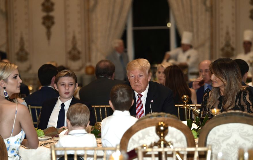 President Donald Trump, center, and first lady Melania Trump, right, sit with their family as they have Thanksgiving Day dinner at their Mar-a-Lago estate in Palm Beach, Fla., Thursday, Nov. 22, 2018. Ivanka Trump, left, and Barron Trump, second from left, attend. (AP Photo/Susan Walsh)