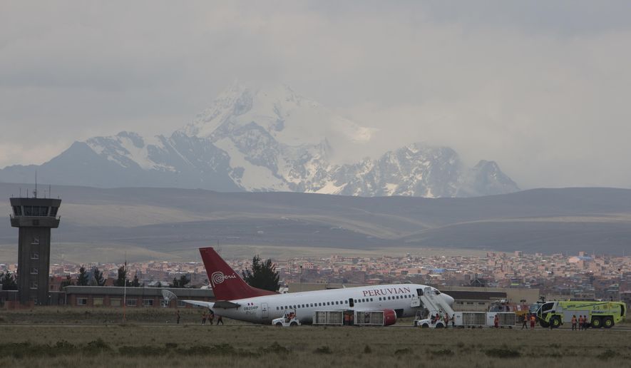 A Peruvian aircraft arriving from Cuzco blocks the runway after having problems landing as workers try to tow it away at the airport in El Alto, Bolivia, Thursday, Nov. 22, 2018. The aircraft blocked the tarmac for several hours, and its occupants were unharmed, according aviation authorities. (AP Photo/Juan Karita)