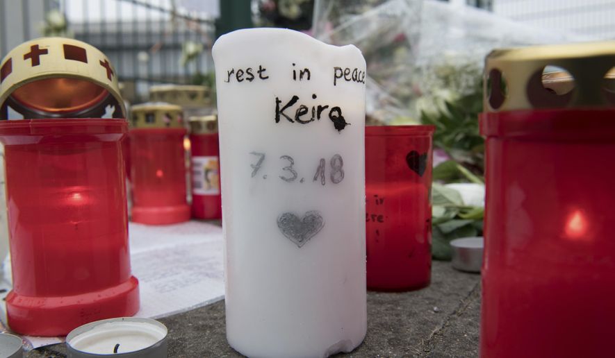 In this Monday, March 12, 2018 photo candles are laid down at the entrance of a sports hall in Berlin, Germany to honor the 14 years old Berlin student Keira who was killed on March 7, 2018. A Berlin court has sentenced a German teenager for killing the 14-year-old girl to nine years in prison in a case that was politically exploited by far-right groups who falsely claimed that the perpetrator was a migrant. (Paul Zinken/dpa via AP)