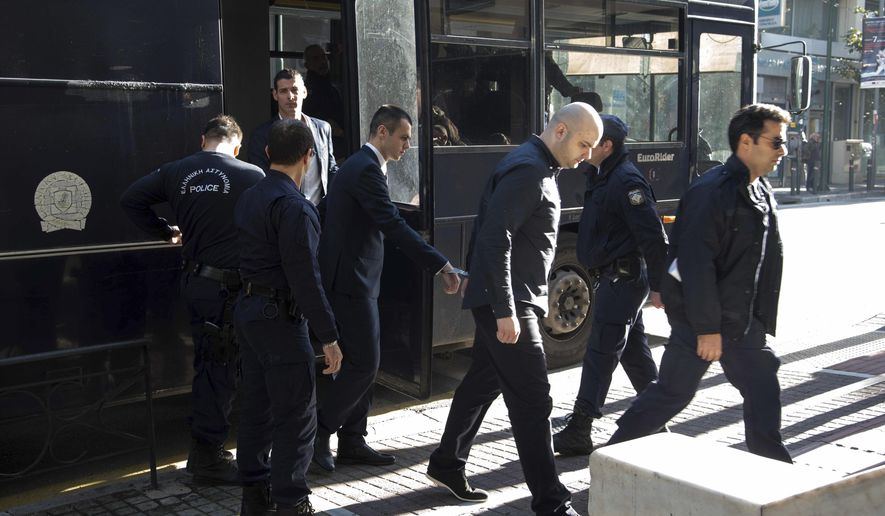 Greek police officers escort three of nine suspects in the fatal beating of an American tourist in an island resort last year, at a court house in Patras, western Greece, on Thursday, Nov. 22, 2018. A Greek court on Thursday convicted and sentenced six of nine suspects in the fatal beating of an American tourist in an island resort last year. Bakari Henderson, a 22-year-old of Austin, Texas, died after being beaten in the street following an argument in a bar in the popular Laganas resort area of Zakynthos island in July 2017. (AP Photo/Giannis Androutsopoulos)