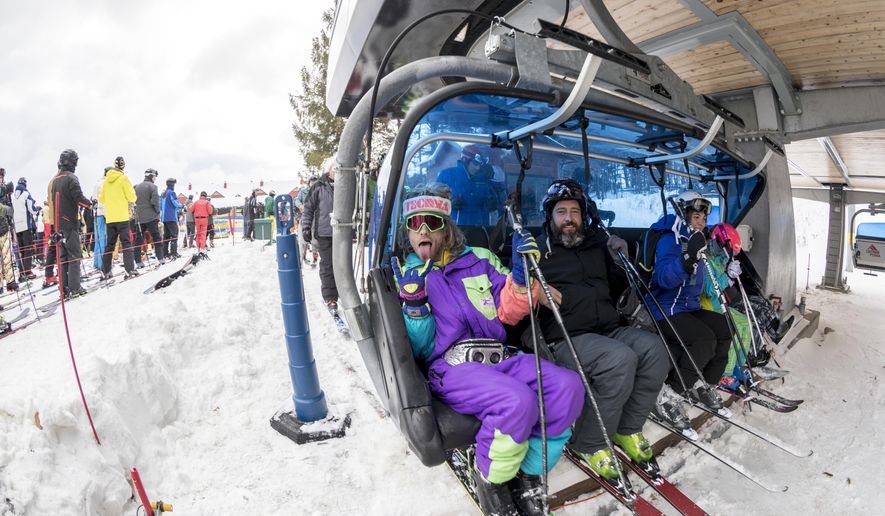 This photo taken Nov. 17, 2018, in West Dover, Vt., shows skiers getting onto a chair lift at the Mount Snow ski resort. Early season snow and cold temperatures are helping New England ski resorts get the 2018-2019 season off to a blizzard of a start. (Brett Miller/Mount Snow via AP)