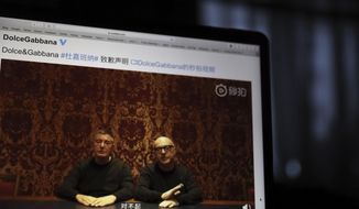 Founders of Dolce&amp;amp;Gabbana Domenico Dolce, left, and Stefano Gabbana apologize in a video on Chinese social media, saying &amp;quot;sorry&amp;quot; in Mandarin seen on a computer screen in Beijing, China, Friday, Nov. 23, 2018. The Italian fashion house has been in hot water for controversial video ads and insulting remarks on China made by Instagram accounts of its co-founder. (AP Photo/Ng Han Guan)
