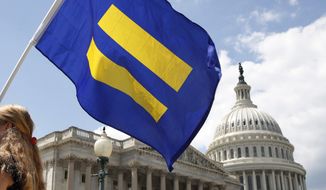 In this July 26, 2017, file photo, a supporter of LGBT rights holds up an &amp;quot;equality flag&amp;quot; on Capitol Hill in Washington, during an event held by Rep. Joe Kennedy, D-Mass., in support of transgender members of the military. (AP Photo/Jacquelyn Martin, File)