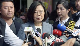 Taiwanese President Tsai Ing-wen, center, speaks to journalists after a vote in local elections in New Taipei City, Taiwan Saturday, Nov. 24, 2018. Taiwanese have begun voting in midterm local elections seen as a referendum on the administration of President Tsai, amid growing pressure from the island&#x27;s powerful rival China. (Kyodo News via AP)