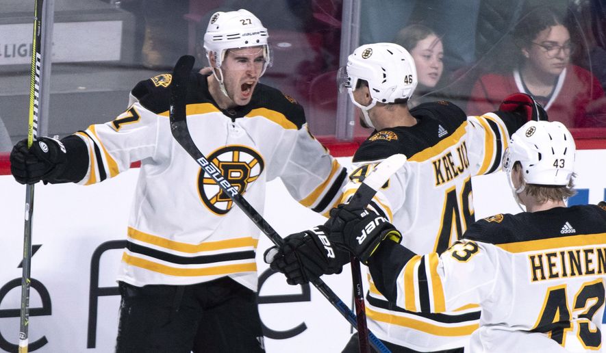 Boston Bruins&#39; John Moore celebrates his goal with teammates David Krejci and Danton Heinen, right, against the Montreal Canadiens during the third period of an NHL hockey game Saturday, Nov. 24, 2018, in Montreal. (Paul Chiasson/The Canadian Press via AP)