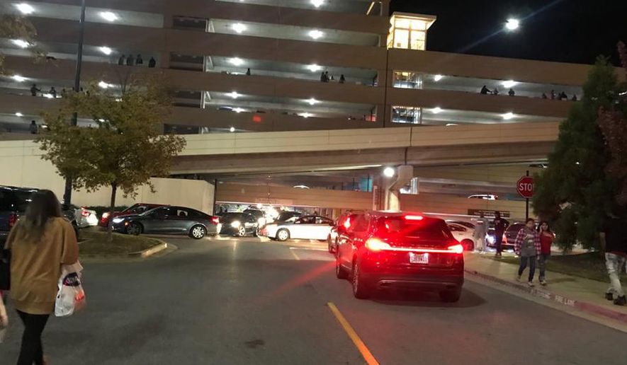 In this Thursday, Nov. 22, 2018 photo, people walk outside the Riverchase Galleria mall after gunfire erupted on the mall's second floor concourse area Thanksgiving night in Hoover, Ala. Police responding to a fight inside the mall shot and killed a man who had brandished a weapon, authorities said Friday. Several other people were injured, including a 12-year-old girl. (Carol Robinson/Press-Register/AL.com via AP)