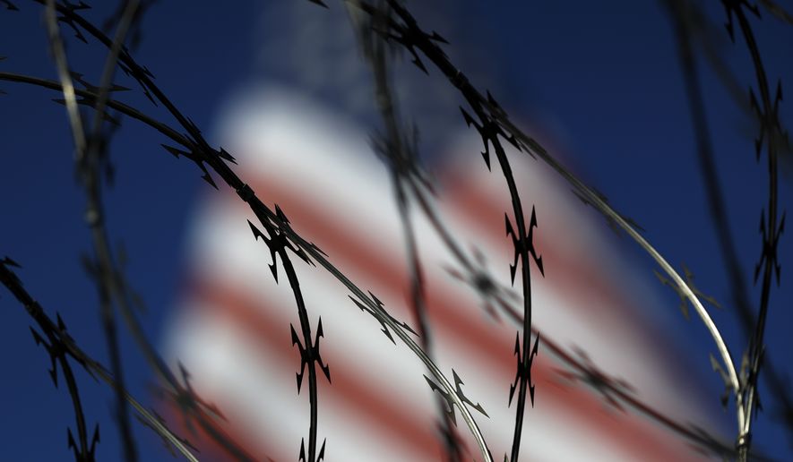 File - In this Nov. 16, 2018 file photo, concertina wire lines the top of a wall at the San Ysidro port of entry in San Diego. The dividing line between the United States and Mexico at the edge of the Pacific Ocean is now more than just a towering metal wall that cuts through the sandy beach. Overnight, workers stacked up rows of coiled wire, hoping to discourage the Central American migrants gathering in Tijuana from crossing illegally. It marks one of numerous spots along the U.S.-Mexico border where soldiers and contractors have been installing different versions of sharp wire barriers. (AP Photo/Gregory Bull, File)
