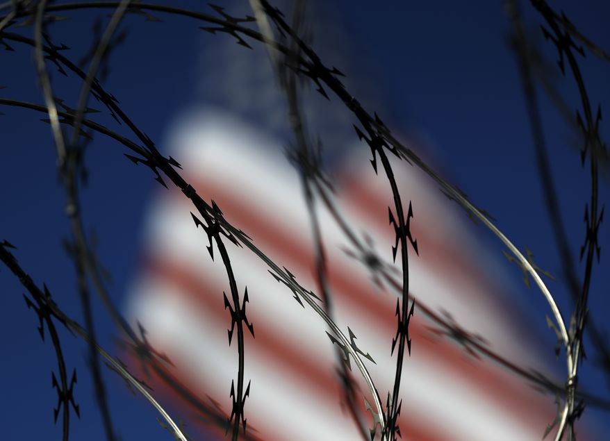 File - In this Nov. 16, 2018 file photo, concertina wire lines the top of a wall at the San Ysidro port of entry in San Diego. The dividing line between the United States and Mexico at the edge of the Pacific Ocean is now more than just a towering metal wall that cuts through the sandy beach. Overnight, workers stacked up rows of coiled wire, hoping to discourage the Central American migrants gathering in Tijuana from crossing illegally. It marks one of numerous spots along the U.S.-Mexico border where soldiers and contractors have been installing different versions of sharp wire barriers. (AP Photo/Gregory Bull, File)