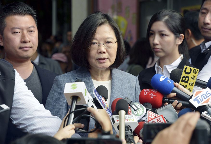 Taiwanese President Tsai Ing-wen, center, speaks to journalists after a vote in local elections in New Taipei City, Taiwan Saturday, Nov. 24, 2018. Taiwanese have begun voting in midterm local elections seen as a referendum on the administration of President Tsai, amid growing pressure from the island&#39;s powerful rival China. (Kyodo News via AP)