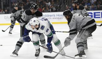 Vancouver Canucks&#39; Tyler Motte, center, is pressured by Los Angeles Kings&#39; Oscar Fantenberg, right, of Sweden, and Alex Iafallo during the first period of an NHL hockey game Saturday, Nov. 24, 2018, in Los Angeles. (AP Photo/Jae C. Hong)