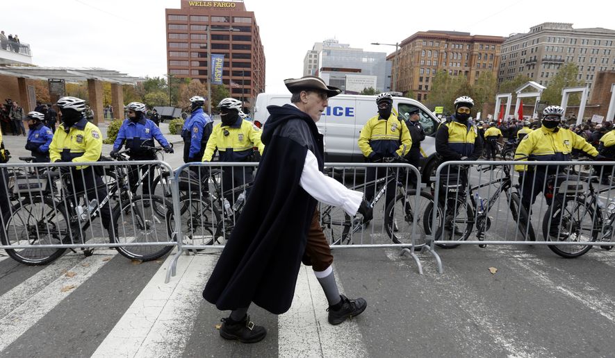 Re-enactor Clark DeLeon walks in front of a police barricade as he crosses Market St., Saturday Nov. 17, 2018. Hundreds assembled to oppose a &quot;We The People&quot;rally, which drew less than fifty supporters. (AP Photo/Jacqueline Larma)