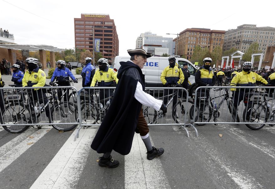 Re-enactor Clark DeLeon walks in front of a police barricade as he crosses Market St., Saturday Nov. 17, 2018. Hundreds assembled to oppose a &quot;We The People&quot;rally, which drew less than fifty supporters. (AP Photo/Jacqueline Larma)