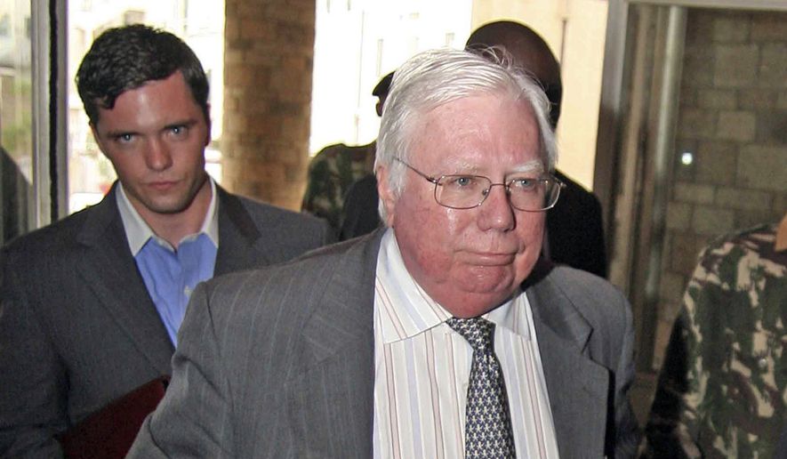 In this Oct. 7, 2008, file photo, Jerome Corsi, right, arrives at the immigration department in Nairobi, Kenya. (AP Photo, File)