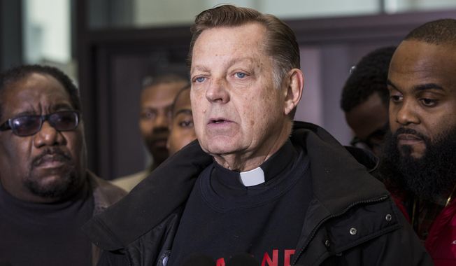 Father Michael Pfleger speaks about the Laquan McDonald shooting in the lobby of the Leighton Criminal Courthouse, in Chicago Tuesday, Nov. 27, 2018. A trial is set to begin Tuesday for one current and two former Chicago police officers accused of trying to cover up what happened when a white officer fatally shot black teenager Laquan McDonald. (Ashlee Rezin/Chicago Sun-Times via AP)