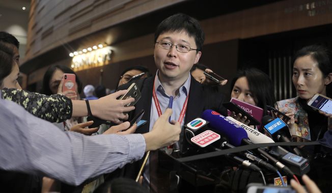 Feng Zhang, center, an institute member of Harvard and MIT&#x27;s Broad Institute, reacts to reporters on the issue of world&#x27;s first genetically edited babies after the Human Genome Editing Conference in Hong Kong, Tuesday, Nov. 27, 2018. He Jiankui, a Chinese researcher, claims that he helped make the world&#x27;s first genetically edited babies twin girls whose DNA he said he altered with a powerful new tool capable of rewriting the very blueprint of life. If true, it would be a profound leap of science and ethics. (AP Photo/Vincent Yu)